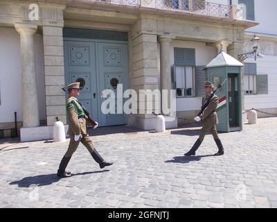 Deux soldats armés se tiennent près de l'entrée de l'édifice sur la garde et gardent les portes au soleil éclatant et en mars Banque D'Images