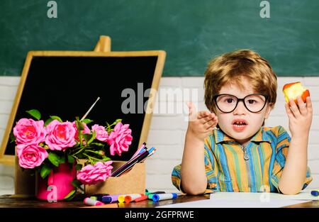 Garçon d'école déjeuner avec pomme. Alimentation saine pour les enfants. Petit élève pendant la pause déjeuner en classe. Banque D'Images