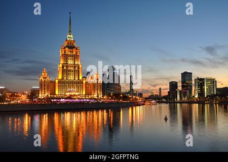 = Hôtel Ukraina et World Trade Centre au crépuscule de printemps = Hôtel Ukraina illuminé (Hôtel Radisson Collection) et bâtiments modernes du commerce mondial Banque D'Images