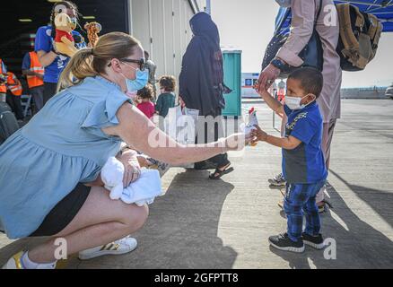 Sigonella, Italie. 26 août 2021. Les membres du département d'État des États-Unis distribuent des jouets et des fournitures aux évacués afghans après leur arrivée à la base aérienne navale de Sigonella le 26 août 2021 à Sigonella, en Italie. NAS Sigonella fournit un hébergement temporaire aux personnes évacuées d'Afghanistan dans le cadre de l'opération alliés refuge. Credit: Planetpix/Alamy Live News Banque D'Images