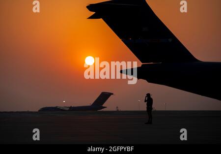 Base aérienne d'Al Udeied, Qatar. 23 août 2021. L'aviateur de l'armée de l'air américaine, doté de la 379e Escadre expéditionnaire de l'air, se prépare à prendre un avion C-17 Globemaster lll pour prendre un taxi jusqu'à la ligne de vol pour le départ à Kaboul en appui de l'opération alliés refuge, le 23 août 2021, à la base aérienne d'Al Udeied, au Qatar. Credit: Planetpix/Alamy Live News Banque D'Images