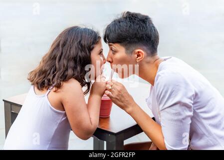 La mère et la fille ont le plaisir de boire du milkshake Banque D'Images