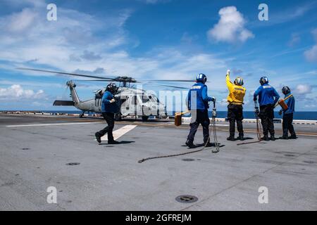 MER DES PHILIPPINES (août 25, 2021) les marins affectés au navire d'assaut amphibie déployé à l'avant USS America (LHA 6) participent aux opérations de vol avec un hélicoptère MH-60S Sea Hawk de l'Escadron de combat de la mer (HSC) 25. L'Amérique et le 31e élément de combat aérien du MEU maintiennent une plate-forme stratégique prête pour une variété de missions. L'Amérique, vaisseau amiral de l'America Expeditionary Strike Group, ainsi que la 31e Marine Expeditionary Unit, opère dans la zone de responsabilité de la 7e flotte des États-Unis pour améliorer l'interopérabilité avec les alliés et les partenaires et servir de force de réponse prête à défendre Banque D'Images