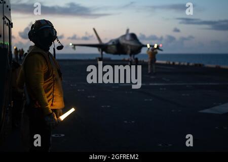 MER DES PHILIPPINES (août 25, 2021) Aviation Boatswain’s Mate (Handling) 1st Class Emmanuel Bonsu, d’Accra, Ghana, affecté au navire d’assaut amphibie déployé à l’avant USS America (LHA 6), libère un avion de chasse F-35B Lightning II de la 31e unité expéditionnaire maritime (MEU) pour le lancement à partir du pont de vol du navire pendant les opérations de vol. L'Amérique et le 31e élément de combat aérien du MEU maintiennent une plate-forme stratégique prête pour une variété de missions. L'Amérique, vaisseau amiral de l'America Expeditionary Strike Group, ainsi que le 31e MEU, opère dans la zone de la 7e flotte américaine de responsabilité à e Banque D'Images