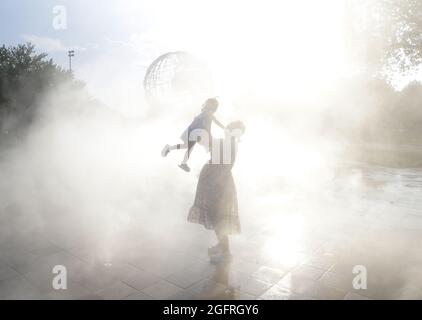 Queens, États-Unis. 26 août 2021. Les gens se rafraîchissent par temps chaud et humide dans le jardin de brume près de la foire mondiale Unisphere à Flushing Meadows-Corona Park à New York le jeudi 26 août 2021. Un avis de chaleur est en vigueur à New York, car les températures élevées et les températures chaudes et humides se poursuivent. Photo de John Angelillo/UPI crédit: UPI/Alay Live News Banque D'Images