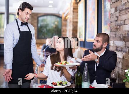 Deux adultes se disent insatisfaits avec serveur sur l'alimentation Banque D'Images