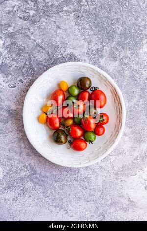 Tomates multicolores dans un bol en céramique Banque D'Images