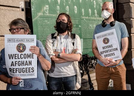 Dublin, Irlande. 26 août 2021. Des manifestants tiennent des pancartes pendant la manifestation.des dizaines de personnes se sont rassemblées devant le Parlement irlandais, la Leinster House, pour exiger que le gouvernement irlandais accueille davantage de réfugiés afghans. United Against racisme a organisé la manifestation, tandis que d'autres partis et organisations comme People before profit, ROSA et le Chéile étaient également présents. Les manifestants ont soutenu que puisque le gouvernement irlandais avait auparavant autorisé l'armée américaine à utiliser l'aéroport de Shannon, l'Irlande ne devrait plus refuser d'accueillir des réfugiés. Crédit : SOPA Images Limited/Alamy Live News Banque D'Images