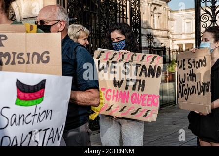 Dublin, Irlande. 26 août 2021. Des manifestants tiennent des pancartes pendant la manifestation.des dizaines de personnes se sont rassemblées devant le Parlement irlandais, la Leinster House, pour exiger que le gouvernement irlandais accueille davantage de réfugiés afghans. United Against racisme a organisé la manifestation, tandis que d'autres partis et organisations comme People before profit, ROSA et le Chéile étaient également présents. Les manifestants ont soutenu que puisque le gouvernement irlandais avait auparavant autorisé l'armée américaine à utiliser l'aéroport de Shannon, l'Irlande ne devrait plus refuser d'accueillir des réfugiés. Crédit : SOPA Images Limited/Alamy Live News Banque D'Images