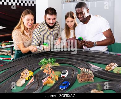 Les couples jouent à la course de voiture de fente de jeu Banque D'Images