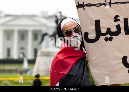 Washington, DC, Etats-Unis, 26 août 2021. Photo : un manifestant tient une bannière lors d’une manifestation contre la première visite de Naftali Bennett à la Maison Blanche en tant que Premier ministre d’Israël. Les manifestants exigent que les États-Unis sanctionnent Israël pour ses attaques continues contre les Palestiniens, y compris le meurtre d'enfants, et le retrait continu des Palestiniens de leurs foyers. Au début du rassemblement, les agents des services secrets ont ordonné aux manifestants de sortir du parc Lafayette. L'ordre est très inhabituel car le Service secret permet des manifestations dans le parc chaque jour. Crédit : Allison Bailey / Alamy Live News Banque D'Images