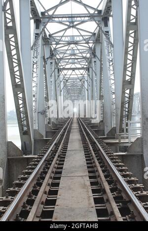 Le pont des chemins de fer indiens dans le Bihar, et les travailleurs de chemin de fer travaillant sur la voie. Banque D'Images