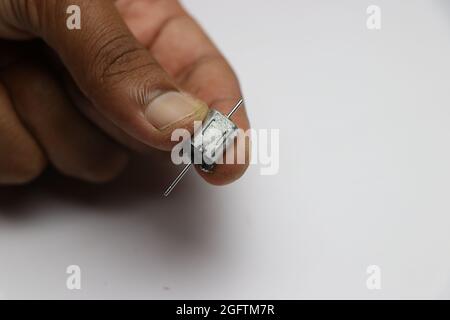 Petit moteur c.c. à double arbre maintenu en main. Moteur micro dc avec 2 arbres utilisé pour réaliser des projets électroniques tels que les petits robots et les voitures Banque D'Images