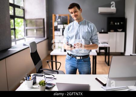 Entrepreneur souriant propriétaire de personne d'affaires au bureau Banque D'Images