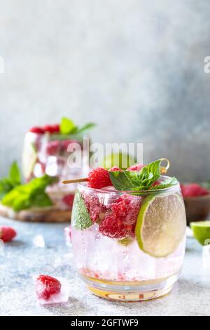 Un cocktail de séltzer dur aux framboises et à la chaux sur une table en pierre grise. Copier l'espace. Banque D'Images