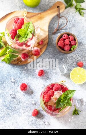 Un cocktail de séltzer dur aux framboises et à la chaux sur une table en pierre grise. Vue de dessus de l'arrière-plan de la mise à plat Banque D'Images