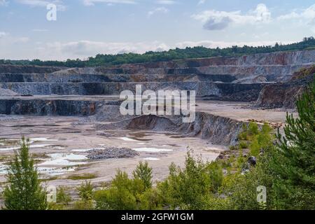 Carrière d'exploitation minière en ouvert avec machines et équipements d'exploitation minière. Extraction de calcaire pour la production de ciment. Banque D'Images