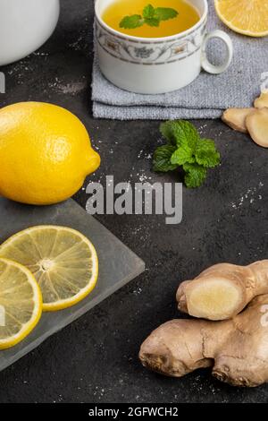 Thé au citron sicilien avec gingembre et feuilles de menthe sur pierre d'ardoise. Banque D'Images