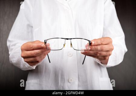 l'ophtalmologiste offre des lunettes au patient, la santé oculaire. Banque D'Images