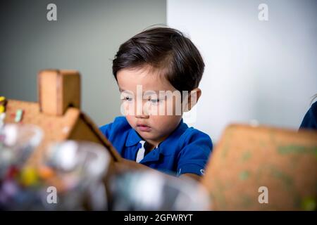 Boy decorating gingerbread house Banque D'Images