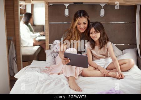 Mère et fille assises sur le lit dans une camionnette de camping Banque D'Images