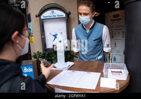 27 août 2021, Bavière, Munich: Un employé d'une auberge vérifie la preuve 3G d'un invité à l'entrée. Les clients du restaurant doivent être vaccinés, testés ou récupérés lorsqu'ils restent à l'intérieur. Photo: Sven Hoppe/dpa Banque D'Images