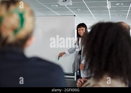 Femme souriante ayant la présentation pendant la réunion d'affaires Banque D'Images