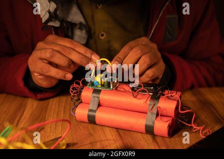 Gros plan des mains de militants ou de Naxalites préparant ou faisant la fabrication de bombes à retardement avec Dynamite - concende la menace ou du danger du terrorisme Banque D'Images