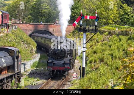 Un moteur à vapeur Standard classe 4 réservoir – 80072 en vapeur à travers un pont avec des voitures de passagers, passant un signal sur le chemin de fer Llangollen au pays de Galles. Banque D'Images