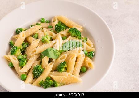 Pâtes aux pois verts, brocoli et parmesan sur fond clair. Banque D'Images