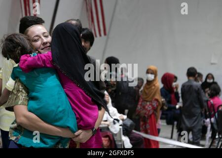 Un soldat central de l'armée américaine accueille des jeunes filles évacuées afghanes avec des hugs pendant le processus d'arrivée au Camp Buehring, au Koweït, le 25 août 2021. Les soldats de l'USARCENT l'ont frappé rapidement avec les enfants à l'installation, trouvant des moyens d'apporter des sourires et des rires à travers le processus. (É.-U. Photo de l'armée par le Sgt. Marc Loi) Banque D'Images