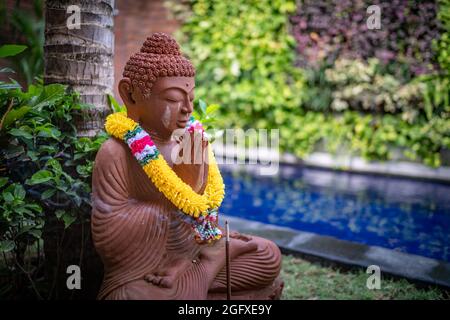 un petit bouddha dans un jardin près de la piscine. Banque D'Images