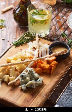 antipasti, différents types de fromage sur une planche de bois avec miel Banque D'Images