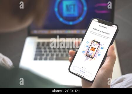 Kharkov, Ukraine - 23 août 2021 : logo de l'application cryptographique Meta Mask sur l'écran du téléphone mobile. Femme utilisant la photo d'application MetaMask NFT Banque D'Images