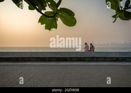 Mumbai, Maharashtra, Inde - 20 novembre 2019 : un couple assis et profitant de la vue sur la mer en fin de soirée avec le coucher du soleil à Nariman point à Mhumb Banque D'Images