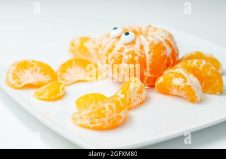 Crabe de fruits, une collation faite de parties fraîches de mandarines servies en forme de crabe, nourriture amusante Banque D'Images