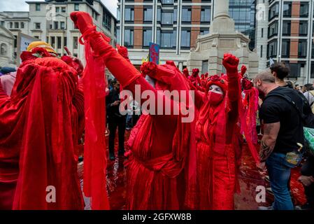 Londres, Royaume-Uni. 27 août 2021. Les rebelles rouges en costume se joignent aux activistes climatiques de la rébellion des extinction qui protestent sur la place Paternoster dans la City de Londres. Cet événement fait partie de la manifestation de la "rébellion impossible" visant à "cibler la cause profonde de la crise climatique et écologique" et se poursuit pendant deux semaines jusqu'à ce que le gouvernement accepte de mettre fin à tous les nouveaux investissements dans les combustibles fossiles. Credit: Stephen Chung / Alamy Live News Banque D'Images