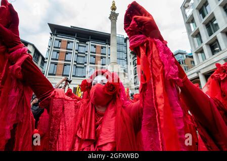 Londres, Royaume-Uni. 27 août 2021. Les rebelles rouges en costume se joignent aux activistes climatiques de la rébellion des extinction qui protestent sur la place Paternoster dans la City de Londres. Cet événement fait partie de la manifestation de la "rébellion impossible" visant à "cibler la cause profonde de la crise climatique et écologique" et se poursuit pendant deux semaines jusqu'à ce que le gouvernement accepte de mettre fin à tous les nouveaux investissements dans les combustibles fossiles. Credit: Stephen Chung / Alamy Live News Banque D'Images