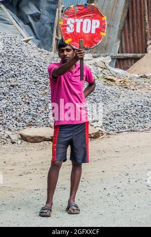ELLA, SRI LANKA - 14 JUILLET 2016 : travailleur local muni d'un panneau d'arrêt près du village d'Ella. Banque D'Images