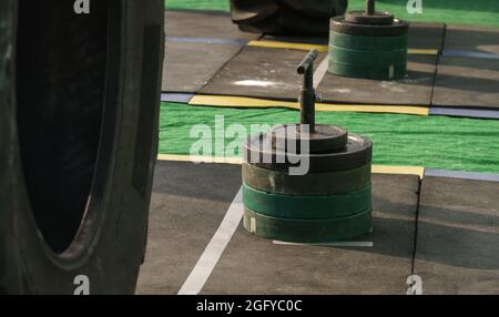 Haltères poids sur barre verticale avec poignées sur le sol en caoutchouc du stade sur la compétition d'homme de fer Banque D'Images
