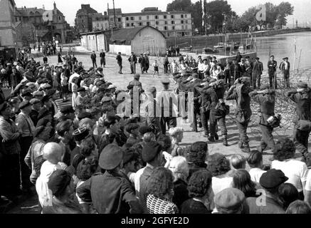 La libération de Honfleur, Normandie, France pendant la seconde guerre mondiale. 26 août 1944. Les habitants de la région regardent les soldats britanniques escorter de jeunes soldats allemands après leur reddition. Banque D'Images