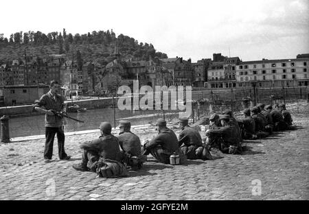 La libération de Honfleur, Normandie, France pendant la seconde guerre mondiale. 26 août 1944. Un combattant de résistance français garde de jeunes soldats allemands après leur capitulation. Banque D'Images