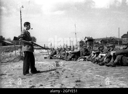 La libération de Honfleur, Normandie, France pendant la seconde guerre mondiale. 26 août 1944. Un combattant de résistance français garde de jeunes soldats allemands après leur capitulation. Banque D'Images