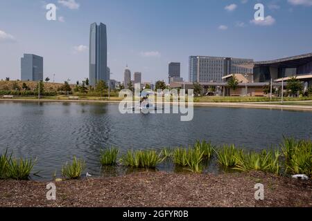 Oklahoma City, Oklahoma. Pédalo au parc Scissortail, avec Devon Tower en arrière-plan, centre de congrès d'Oklahoma City sur la droite. Banque D'Images