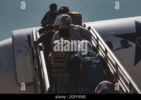 Les évacués embarquent à bord d'un avion pour évacuation à l'aéroport international Hamid Karzaï, en Afghanistan, en août 25. Les membres du service américain aident le ministère d'État à effectuer une opération d'évacuation non combattantes (NEO) en Afghanistan. (É.-U. Photo du corps marin par Cpl. Davis Harris) Banque D'Images