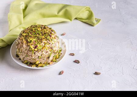 Halva de sésame avec pistaches sur le dessus, quelques noix éparses, serviette en lin vert et espace de copie. Délice turc. Bonbons traditionnels du Moyen-Orient. Juif Banque D'Images