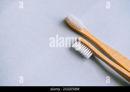 Brosses à dents en bambou à base de matériaux naturels, isolées sur fond gris, gros plan. Banque D'Images