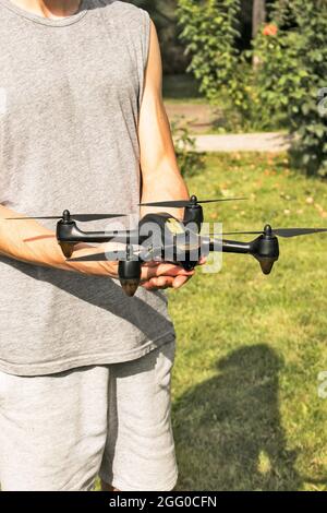 Petit quadriptère moderne et compact dans la main d'un homme. Lancer un drone de votre main. Banque D'Images