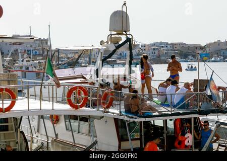 Lampedusa, Italie. 27 août 2021. L'industrie touristique de la fin de l'été remplit le port de Lampedusa. La minuscule île méditerranéenne italienne de Lampedusa, à environ 50 kilomètres de la Tunisie par mer, est souvent le premier contact européen pour les migrants et les réfugiés, et a été inondée par ces deux pays par intermittence. (Photo de John Rudoff/Sipa USA) crédit: SIPA USA/Alay Live News Banque D'Images