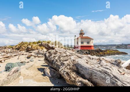 Bandon, Oregon, États-Unis. Les rondins de la plage et le phare de la rivière Coquille sur la côte de l'Oregon. Banque D'Images